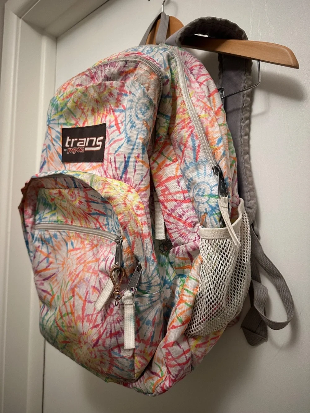 JanSport Trans backpack in a colorful multicolor floral/tie-dye style print